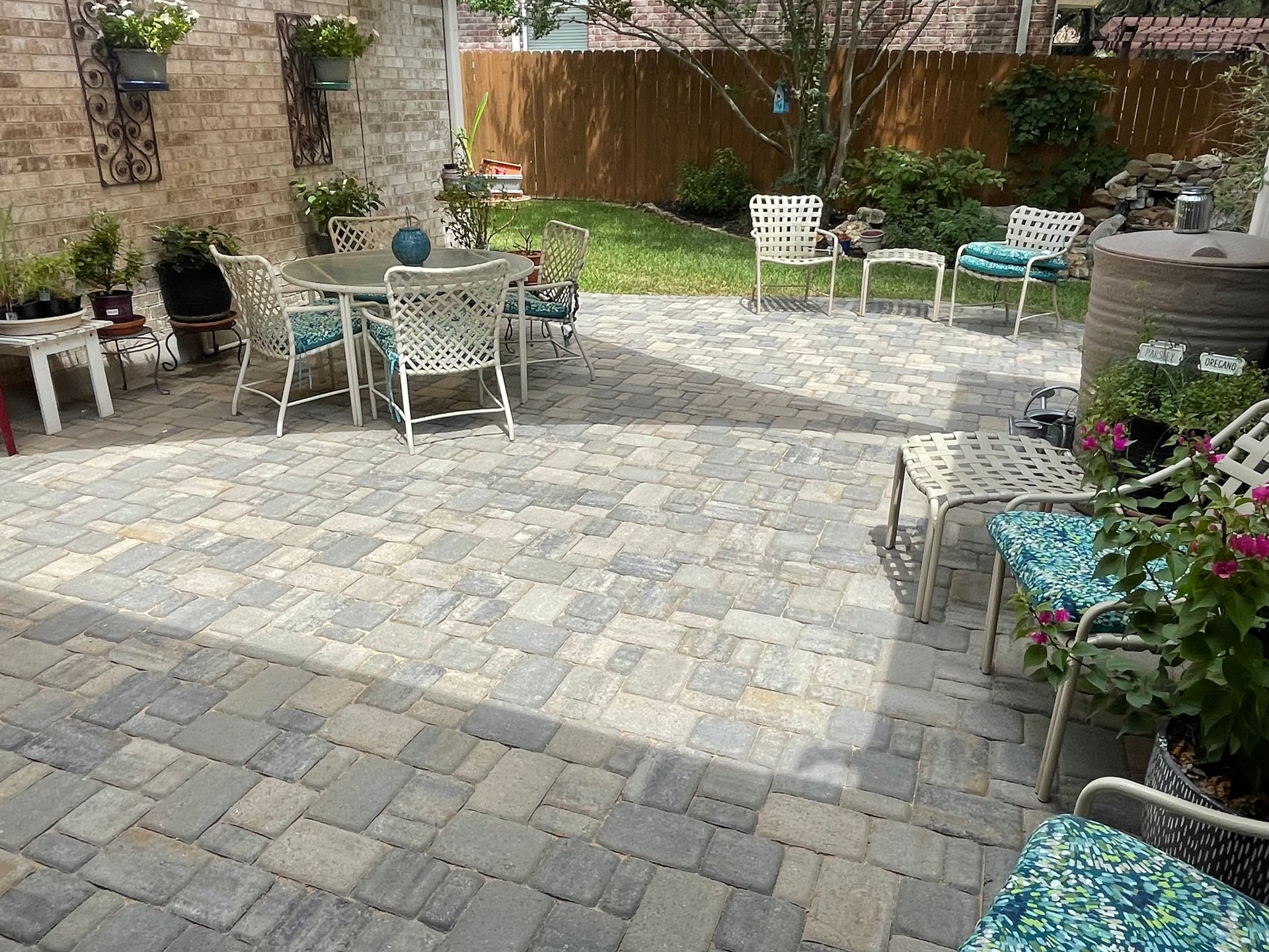 A backyard patio with light and dark grey stone pavers.
