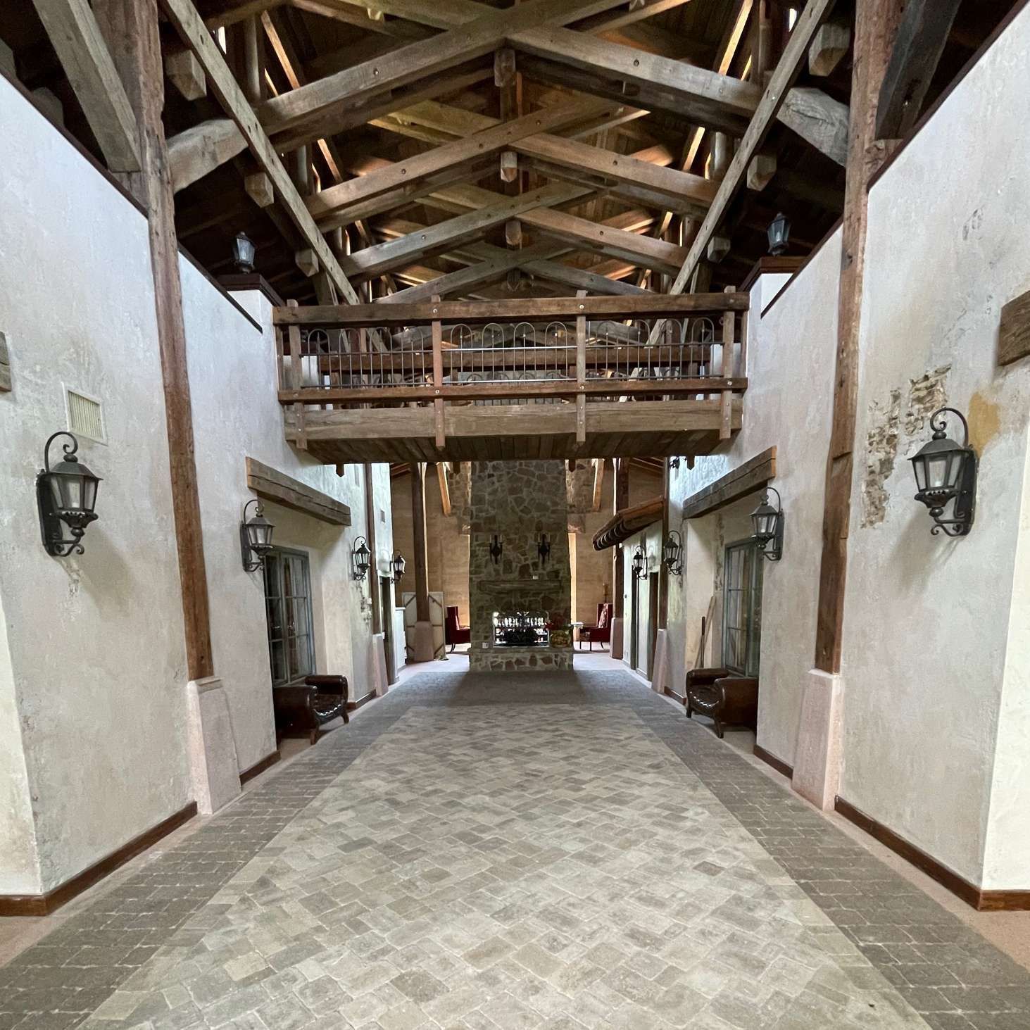 A vaulted hall with wooden rafters, stone walls, a central balcony.