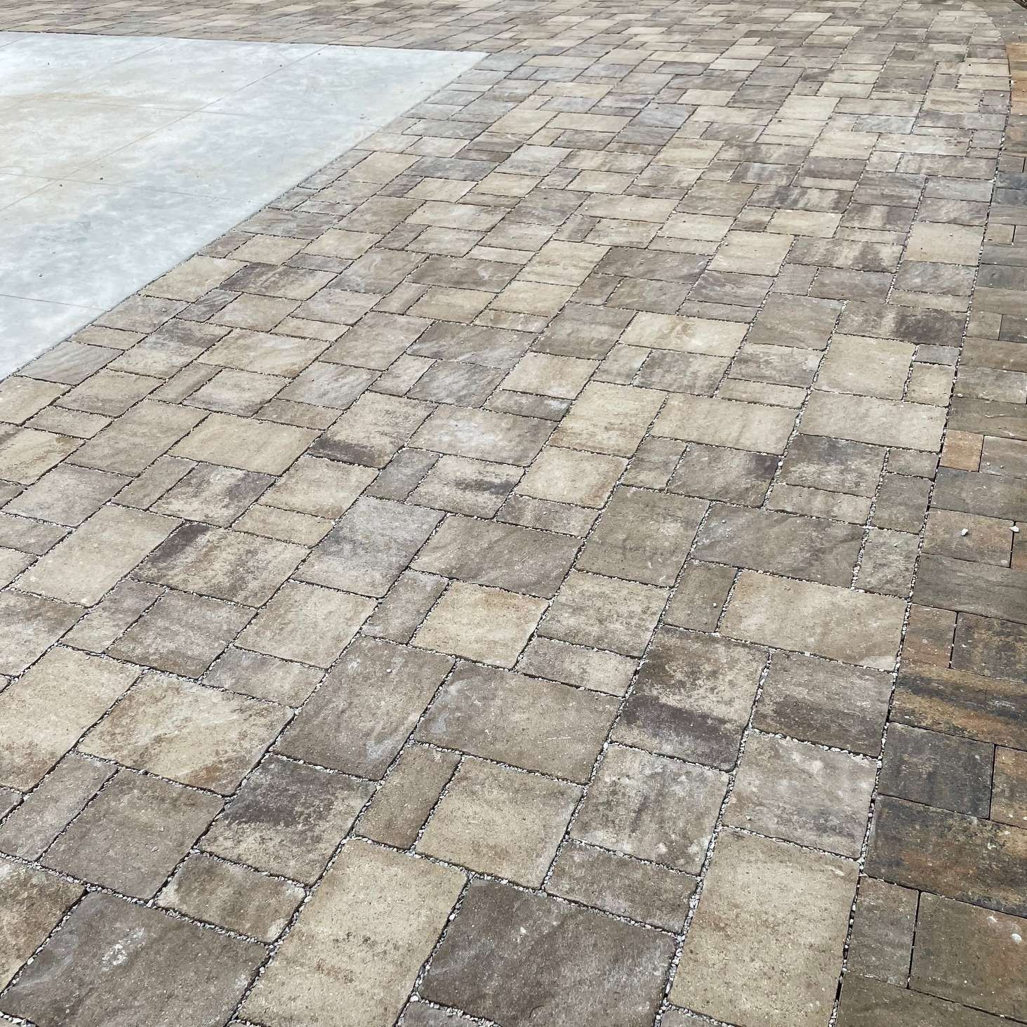 An outdoor patio paved with rectangular stones in varying shades of tan.