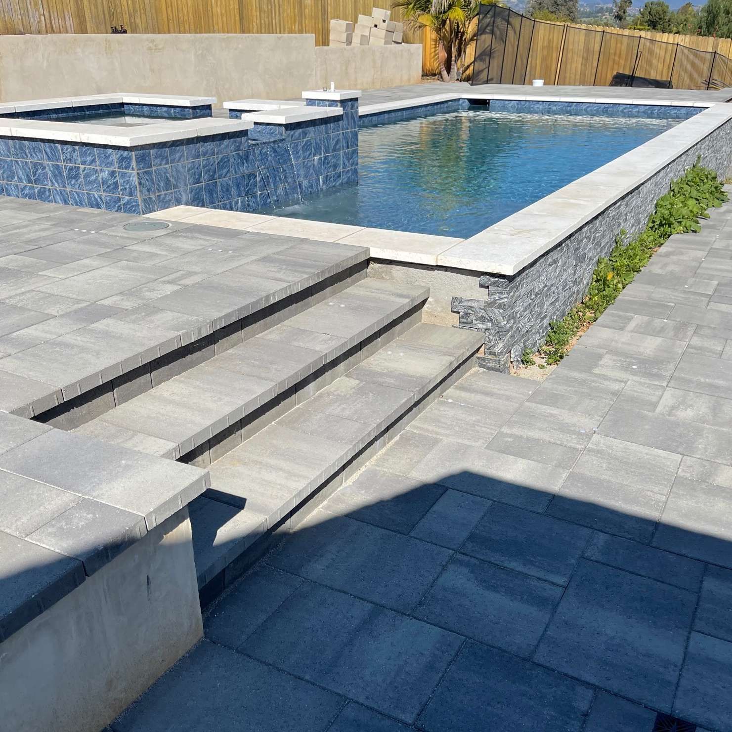 A backyard pool with a raised spa.