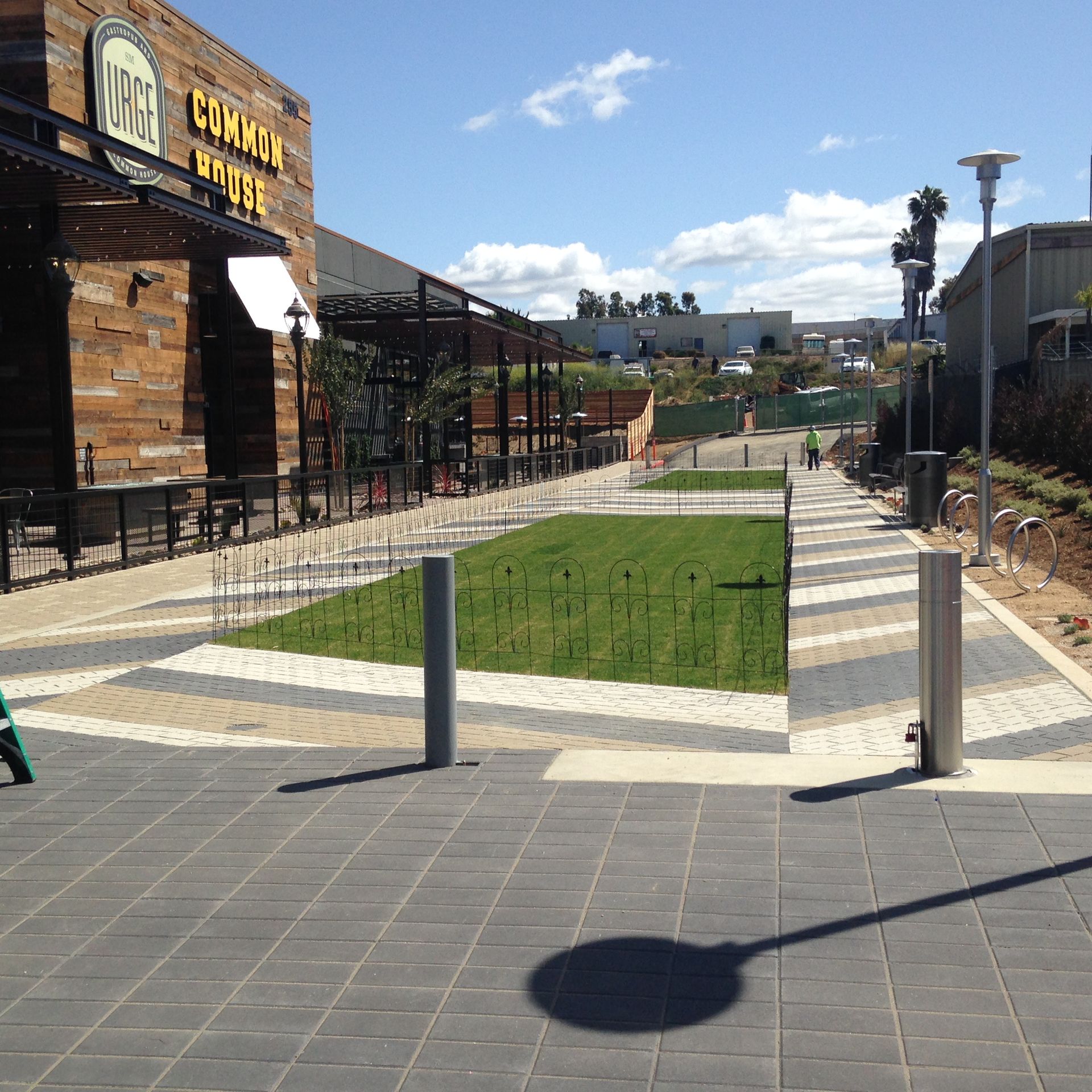 A modern outdoor dining area with a grassy median.