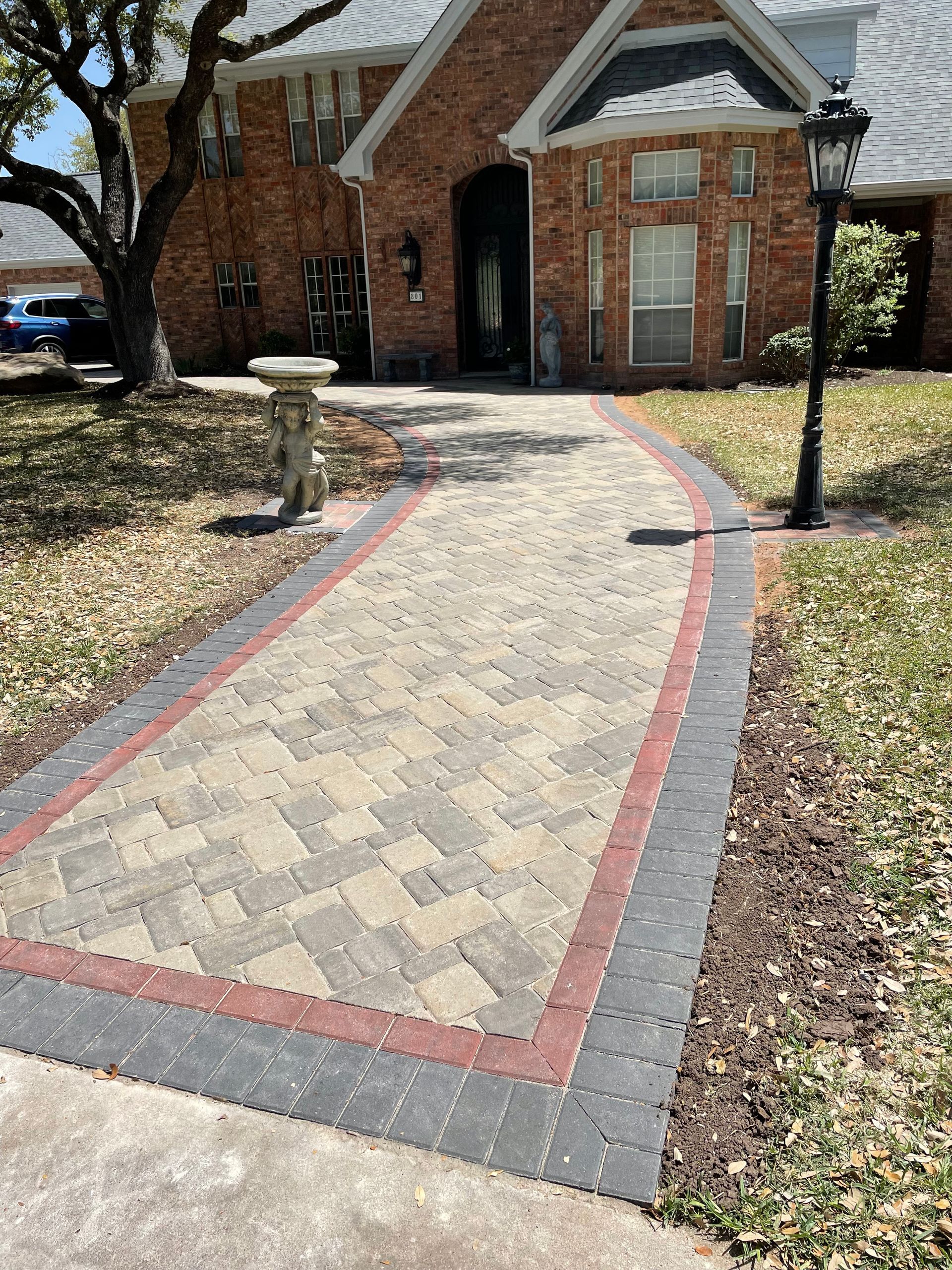 A brick walkway with a herringbone center.