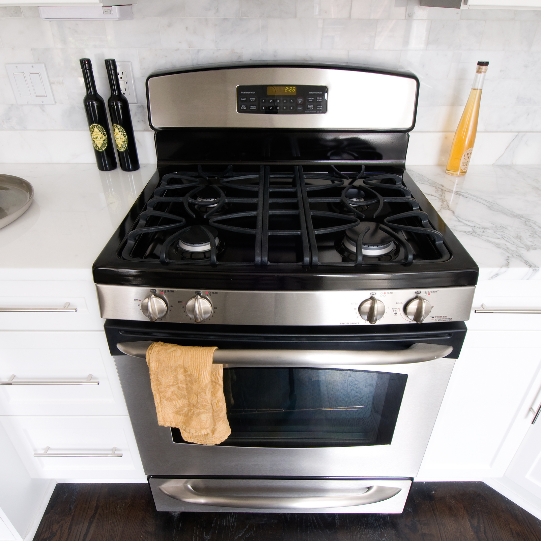 A stainless steel stove top oven with a towel on the door