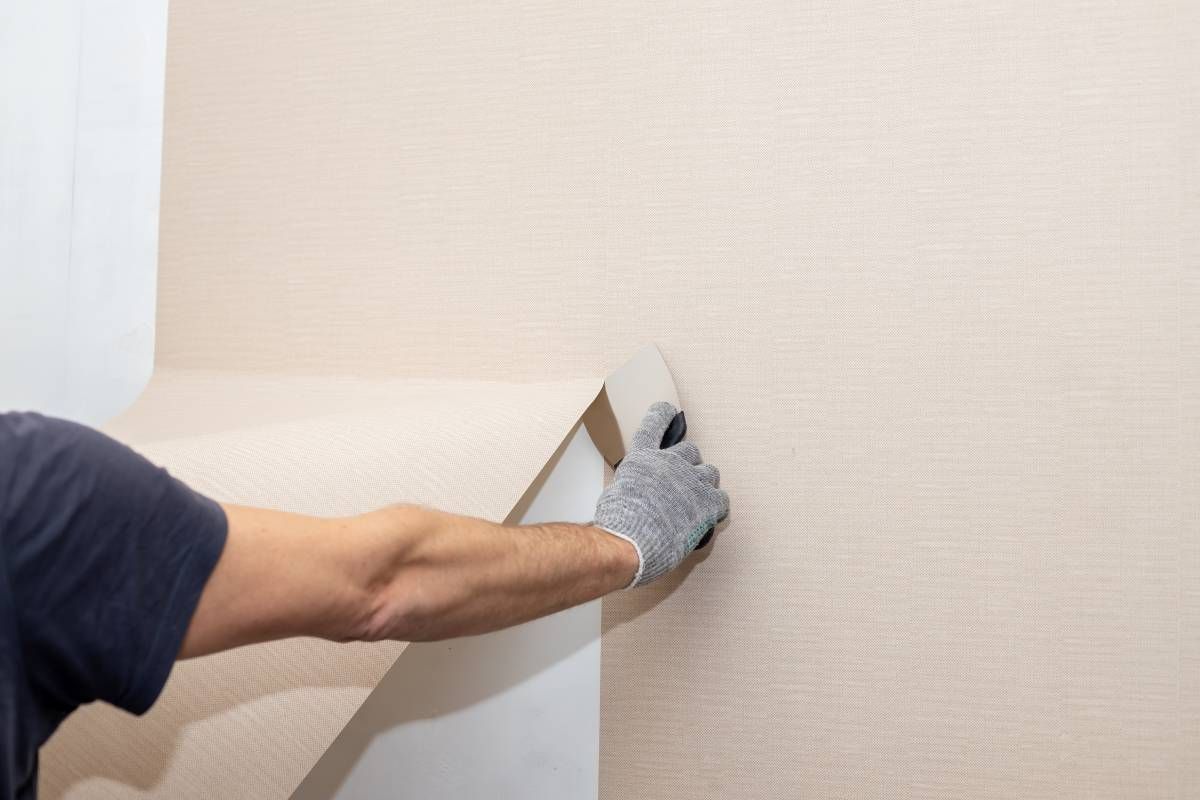 Someone removing wallpaper from a wall at The Painted Horse near Lexington, KY