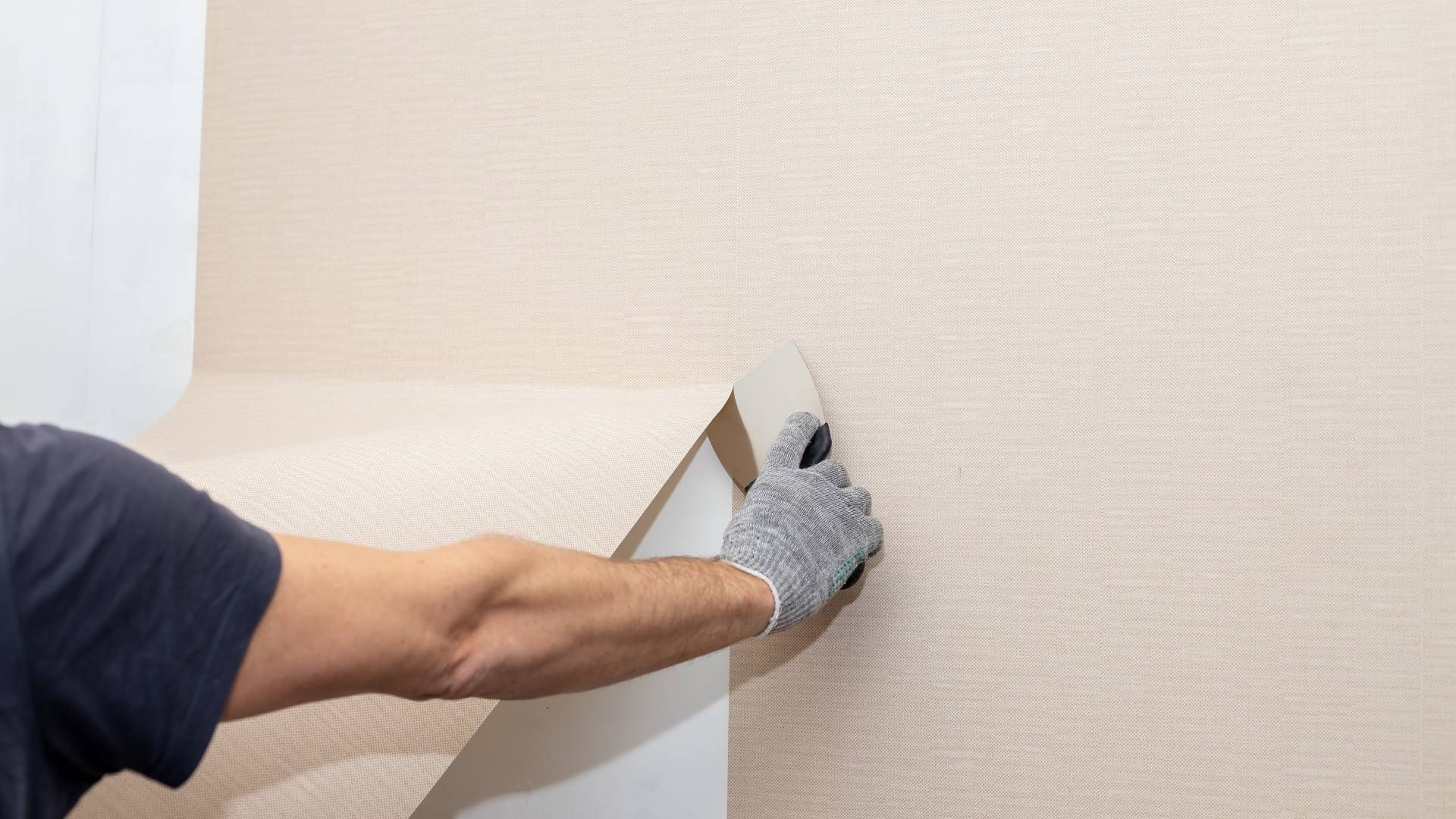 Someone removing wallpaper from a wall at The Painted Horse near Lexington, KY