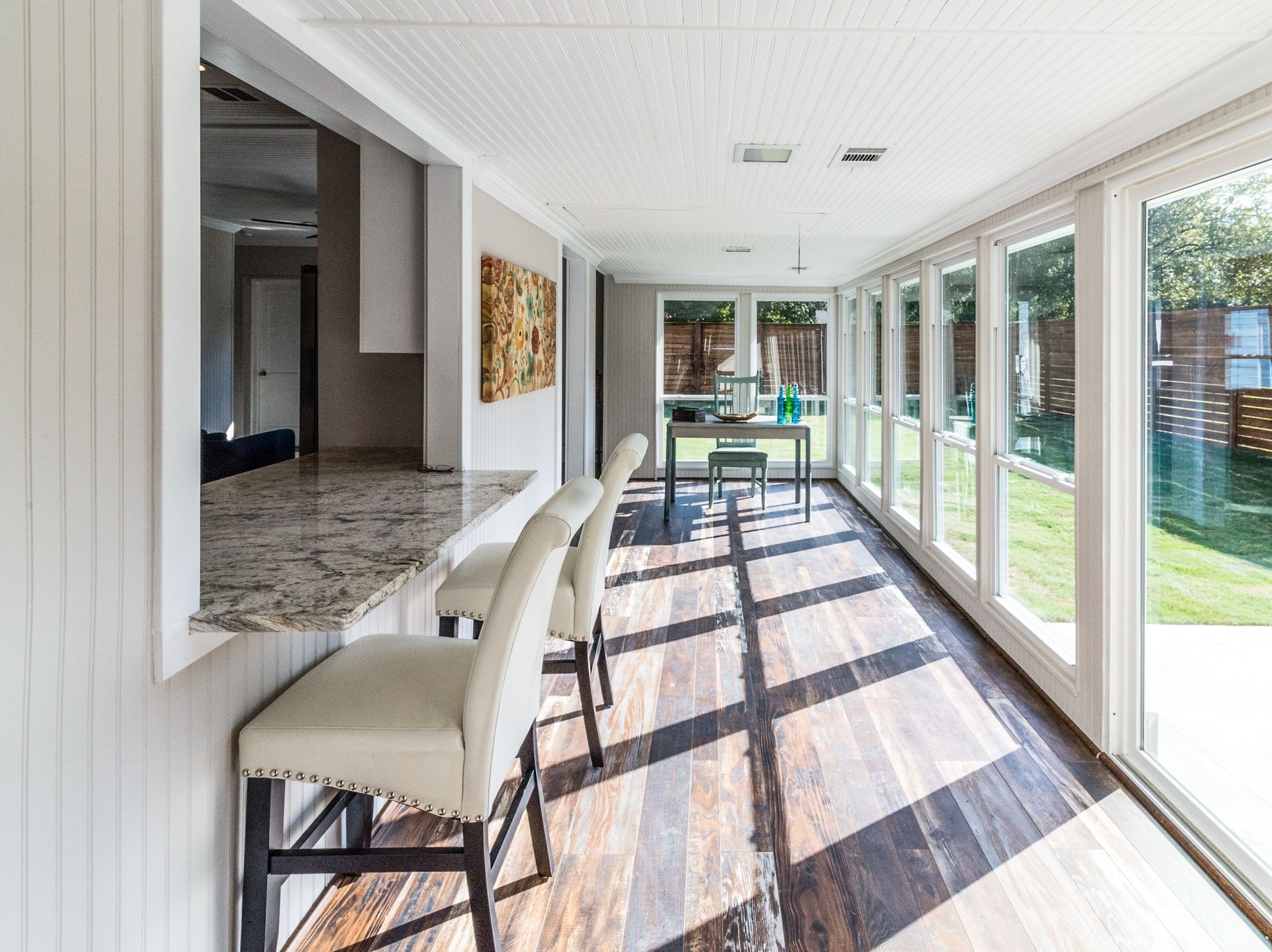 Modern sunroom flooded with natural lighting with bar seating