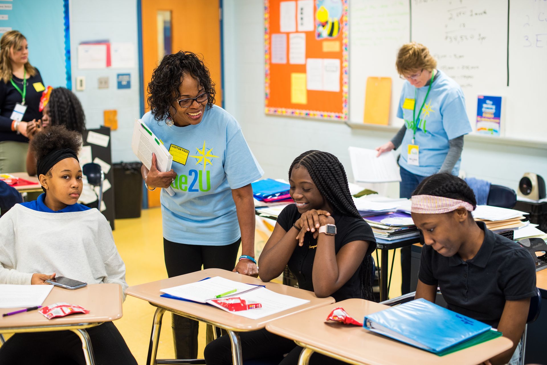 A teacher is talking to a group of students in a classroom.