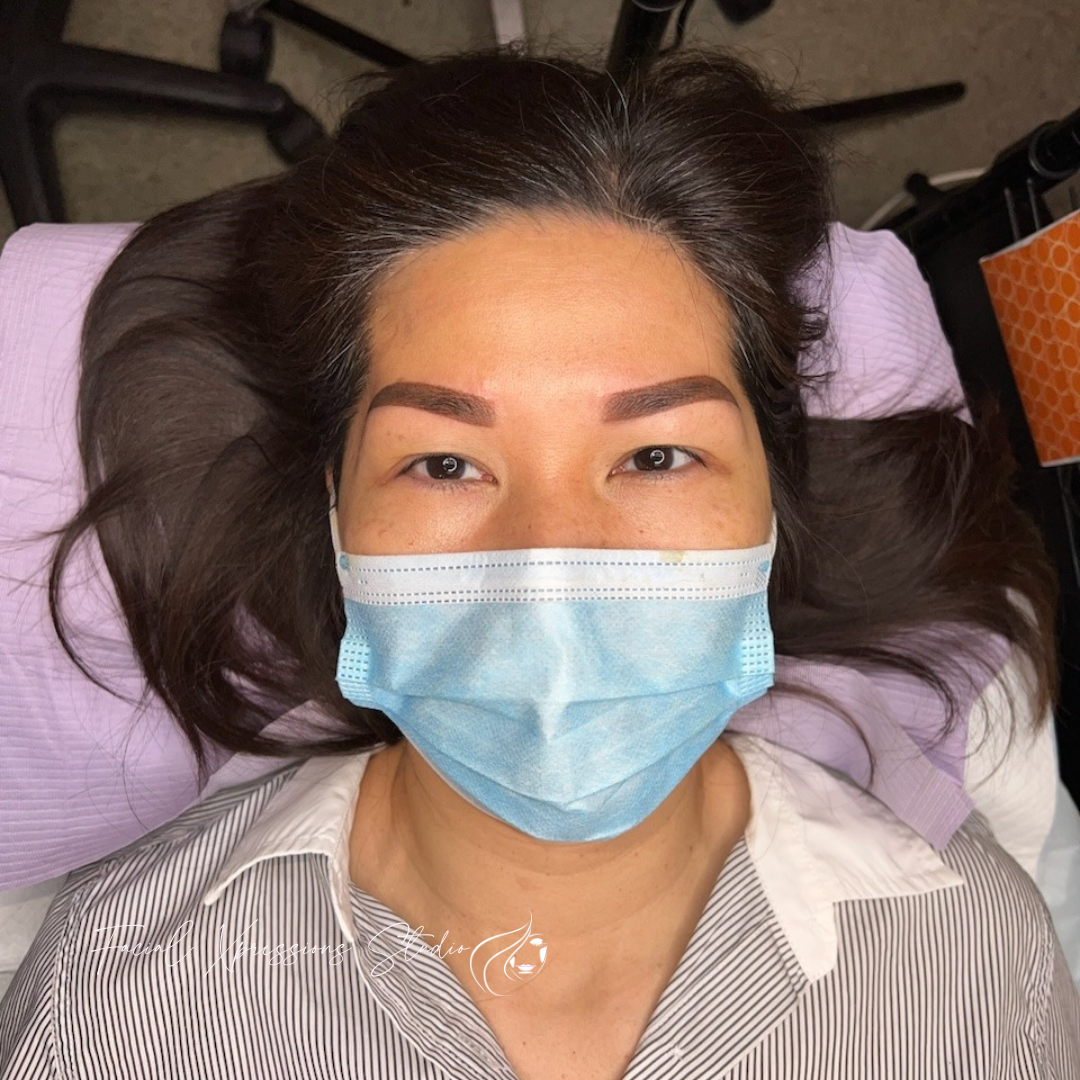 A woman wearing a blue face mask is laying on a bed.