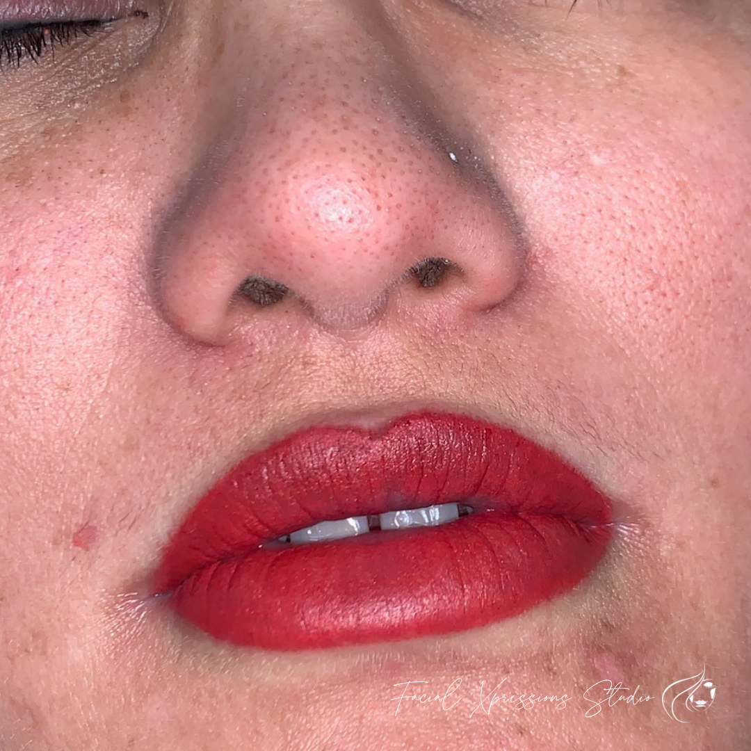 A close up of a woman 's face with red lips.