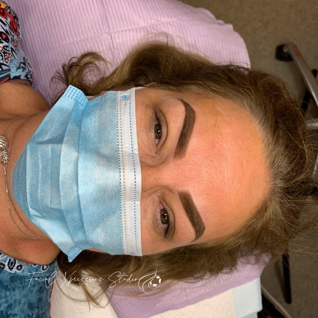 A woman wearing a blue face mask is laying on a bed.