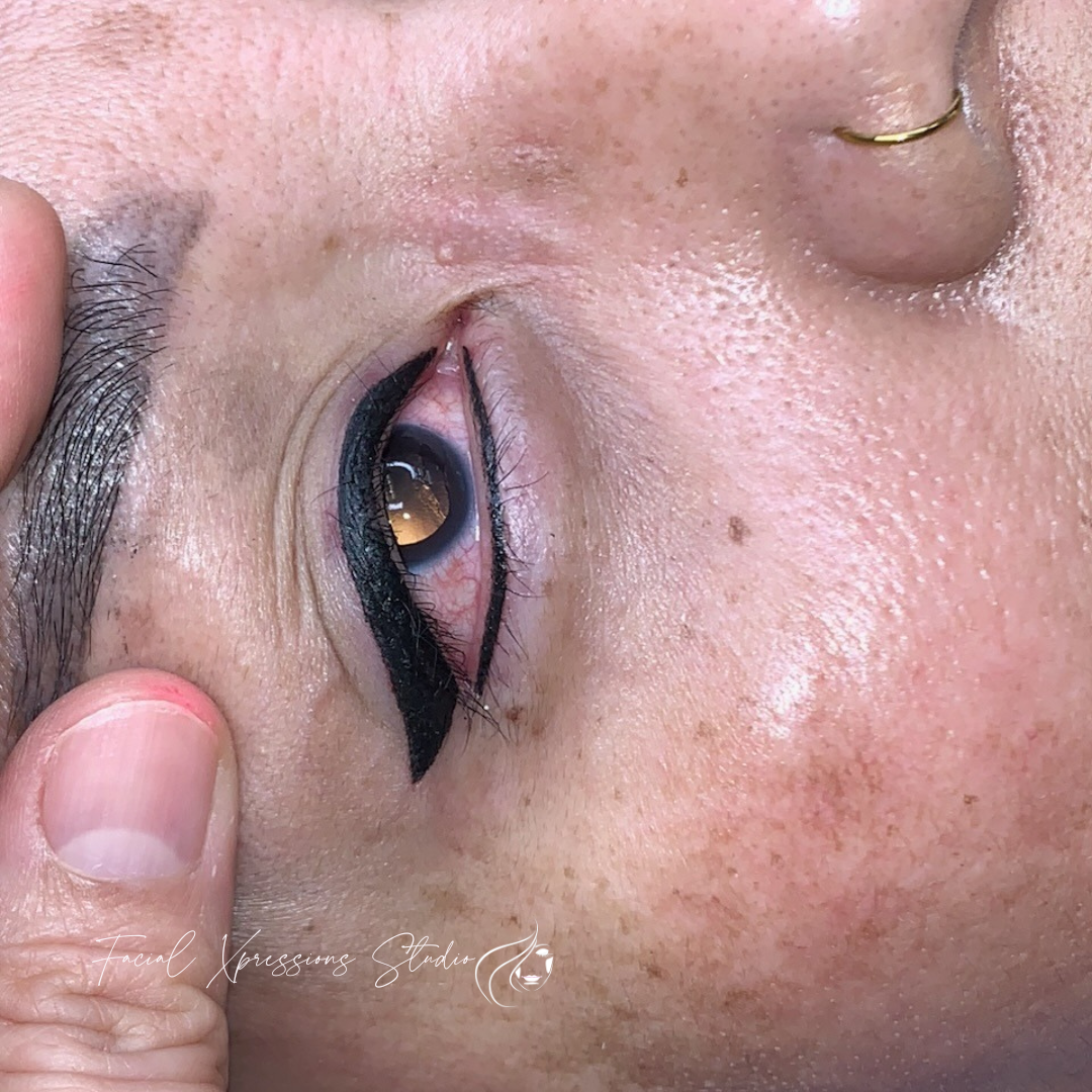A close up of a woman 's eye with a black eyeliner.