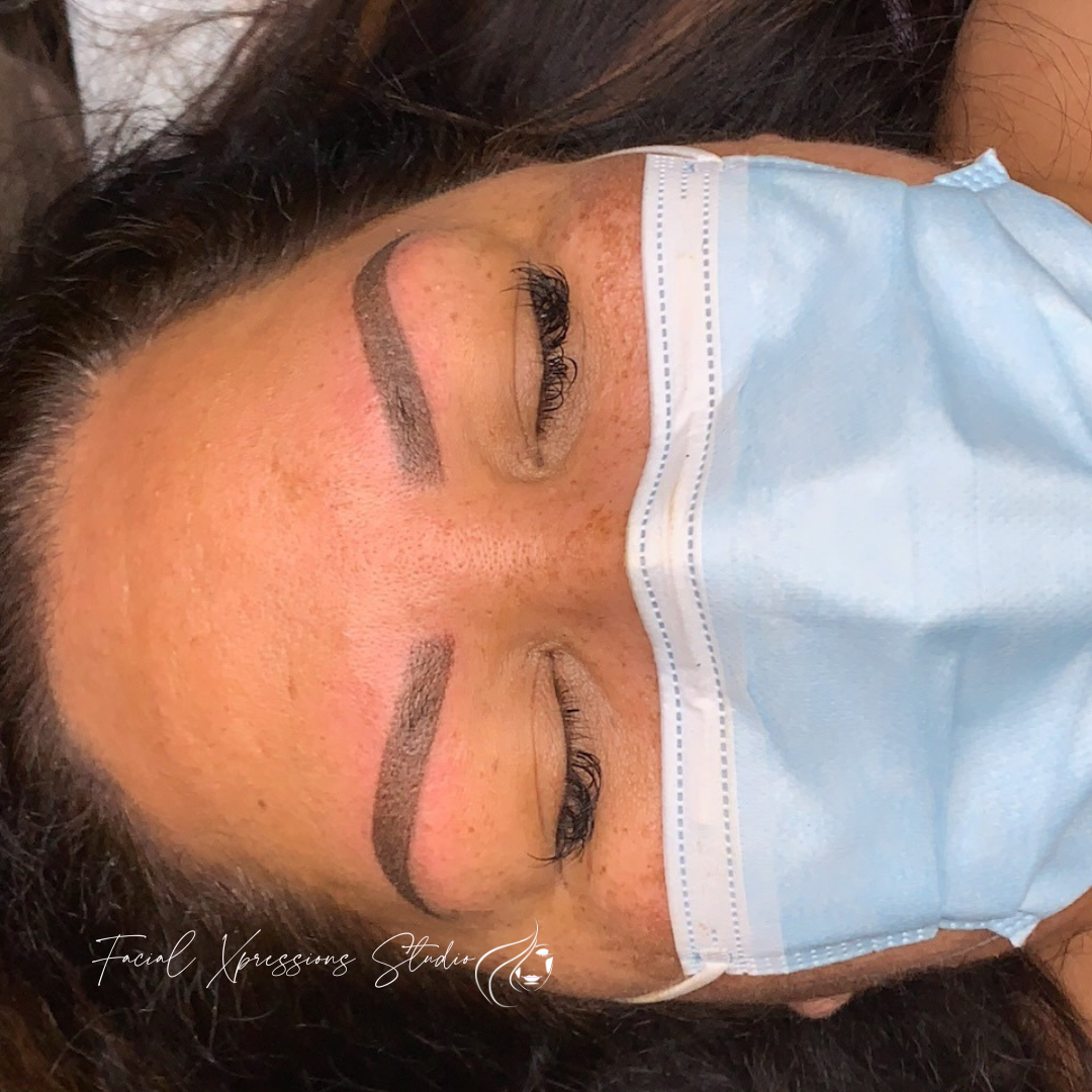 A woman wearing a blue face mask with her eyes closed.