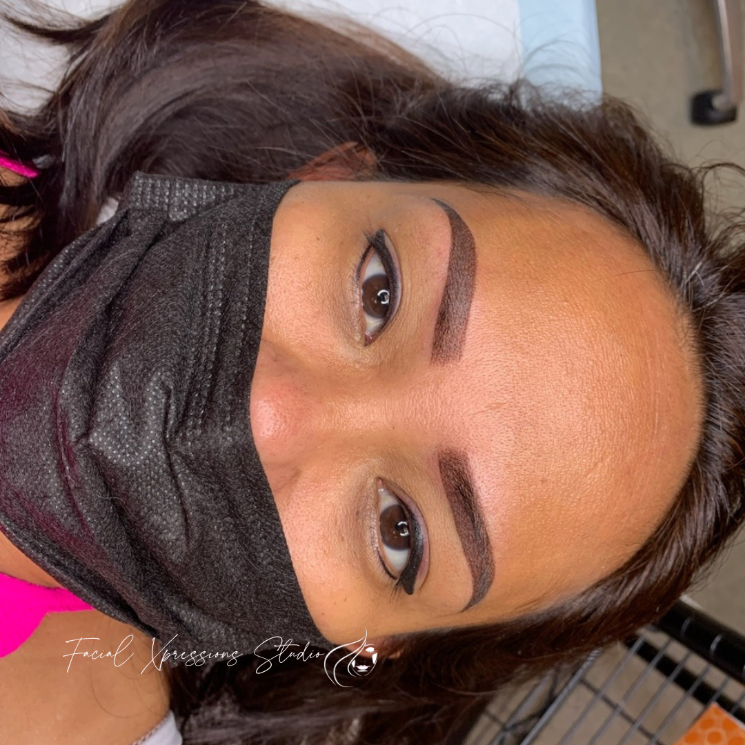 A woman is wearing a black mask on her face.