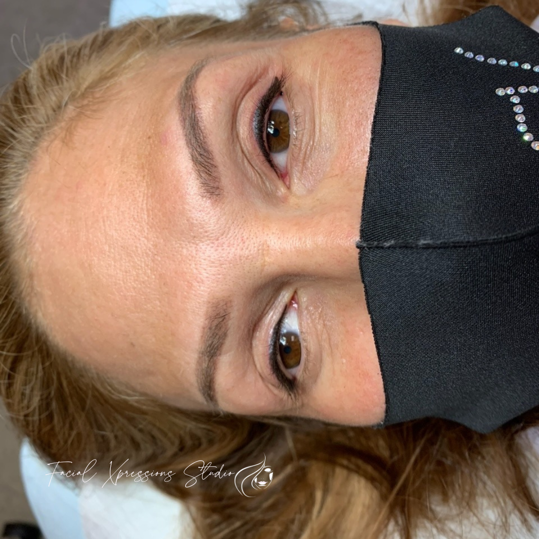 A woman is wearing a black mask on her face.