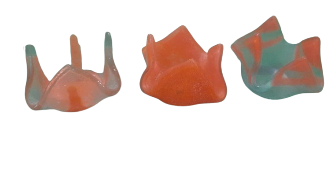 Una mano sostiene un objeto naranja en forma de flor.