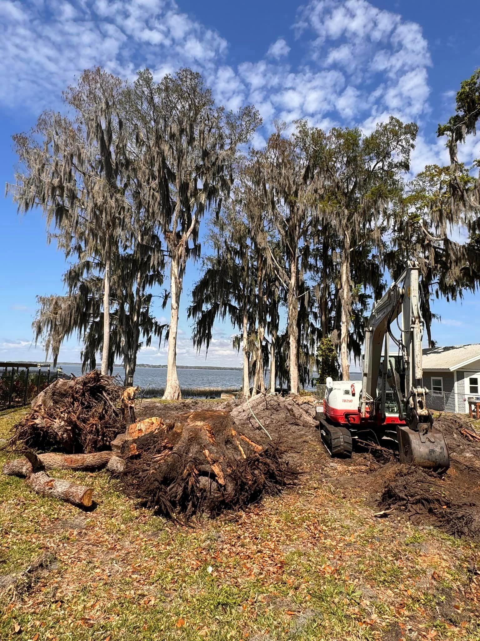 A bulldozer is digging in a field with trees in the background.