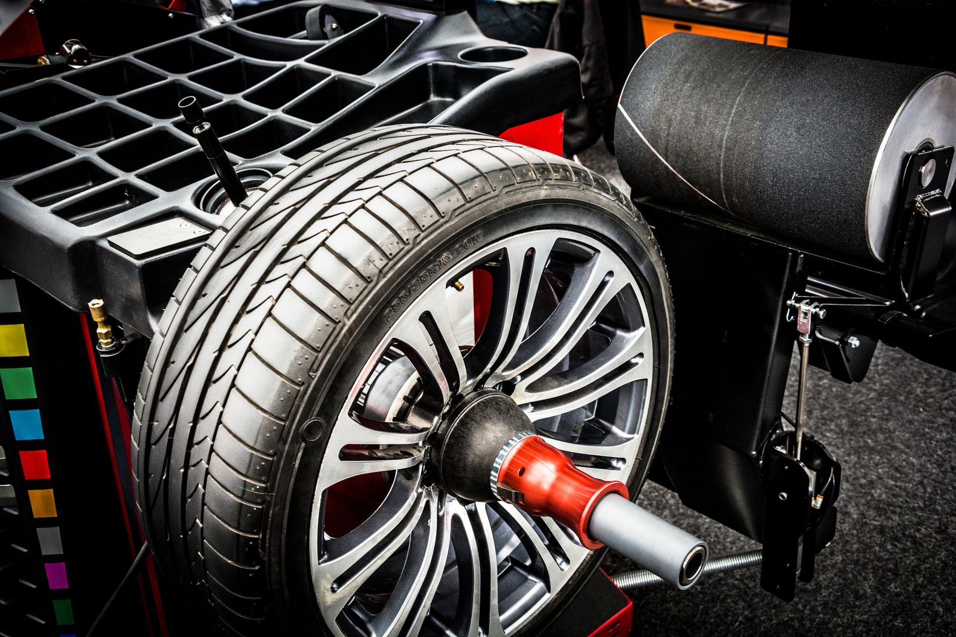 A close up of a tire being balanced on a machine.