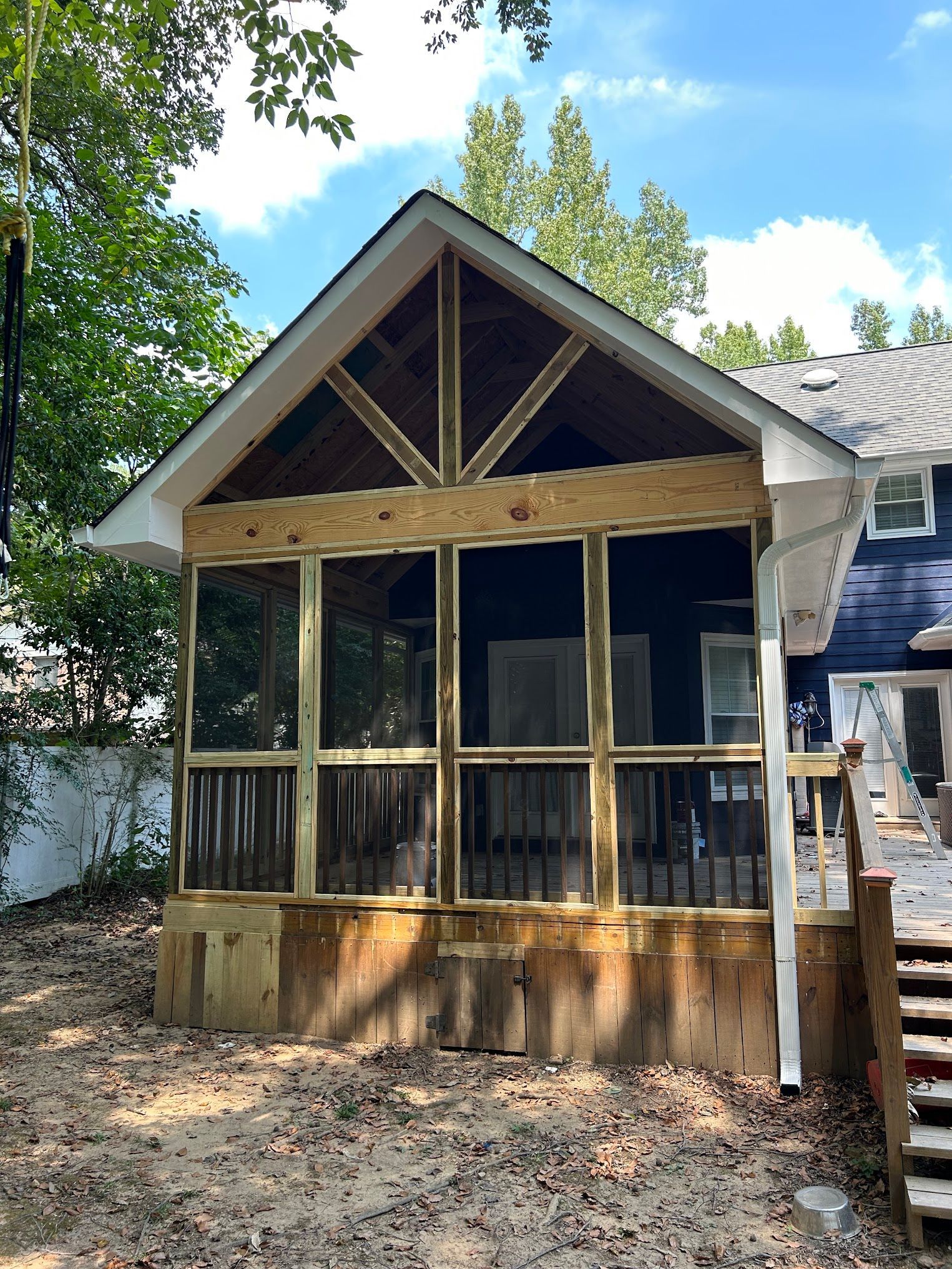 A screened in porch is being built on the side of a house.