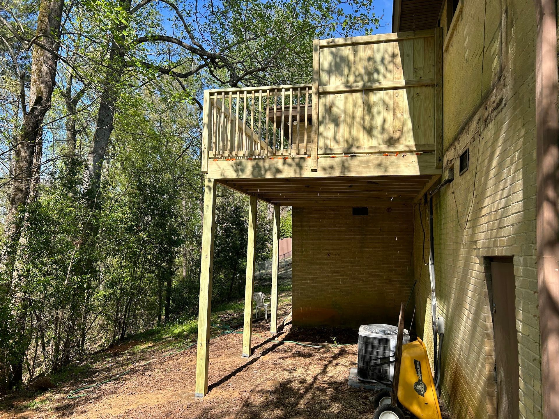 A wooden deck is being built on the side of a house.