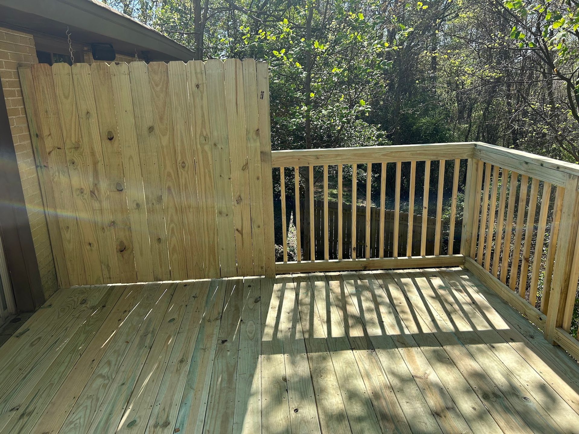A wooden deck with a wooden fence surrounding it.