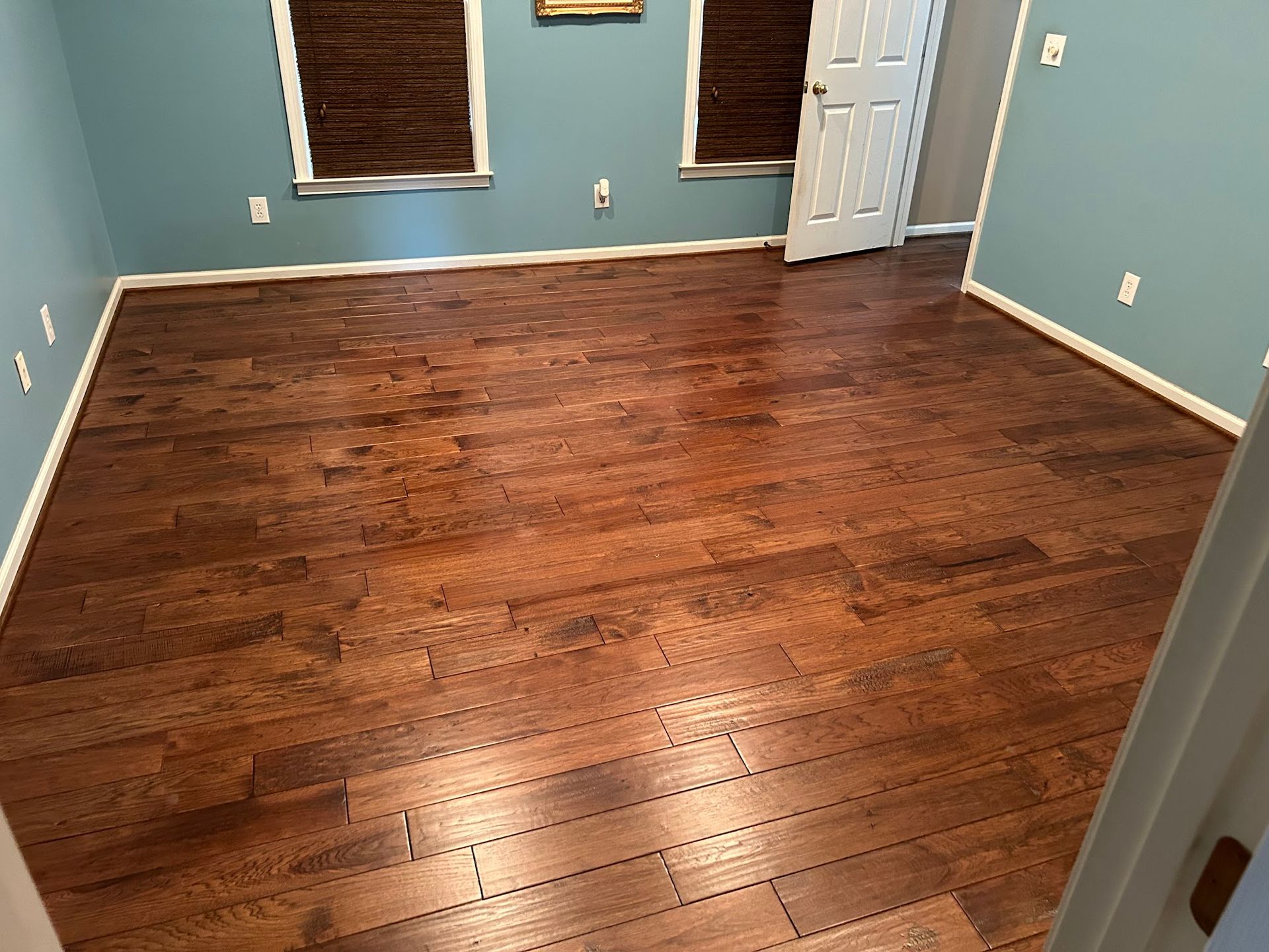 A bedroom with hardwood floors and blue walls.