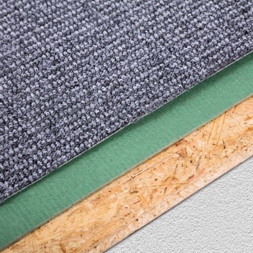 A cross-section view showing gray carpet on green underlayment, layered over OSB wood and a concrete subfloor.