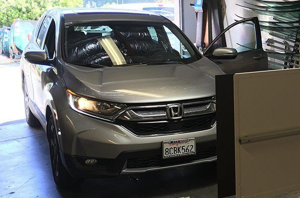 A silver honda cr v is parked in a garage.