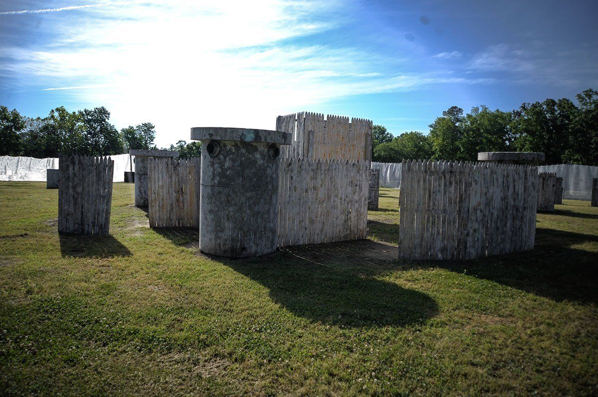A paintball field with a lot of bunkers and trees in the background.