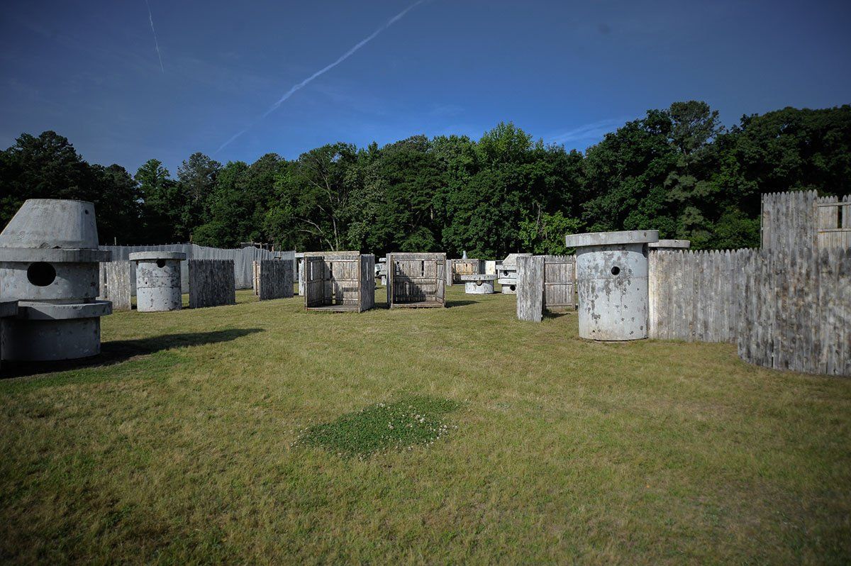 A paintball field with a lot of bunkers and trees in the background.
