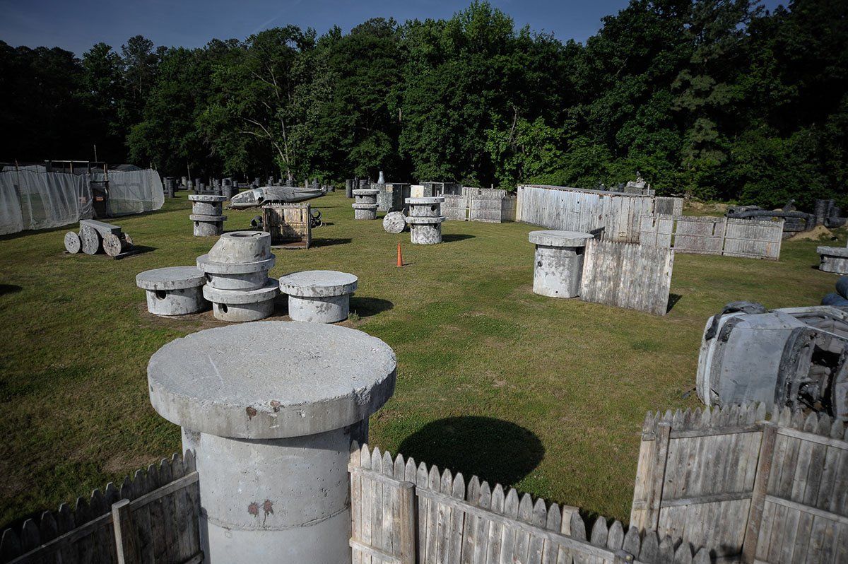 A paintball field with a wooden fence and a lot of concrete columns.
