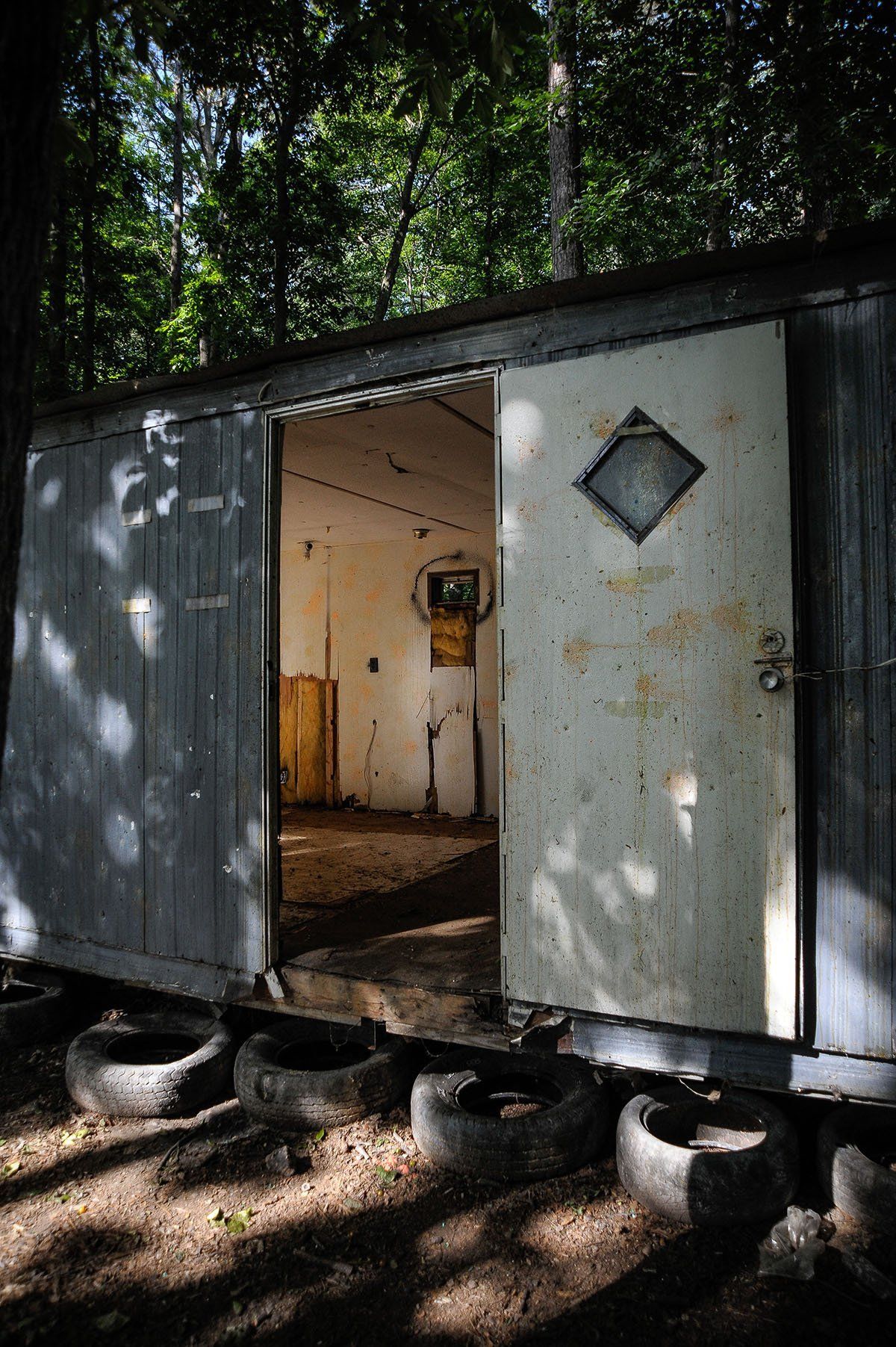 An old shed with the door open in the woods