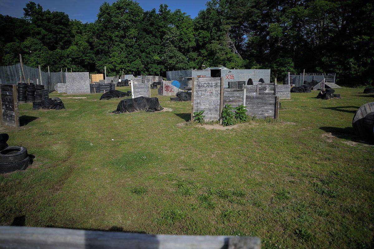 A paintball field with a lot of markers and trees in the background