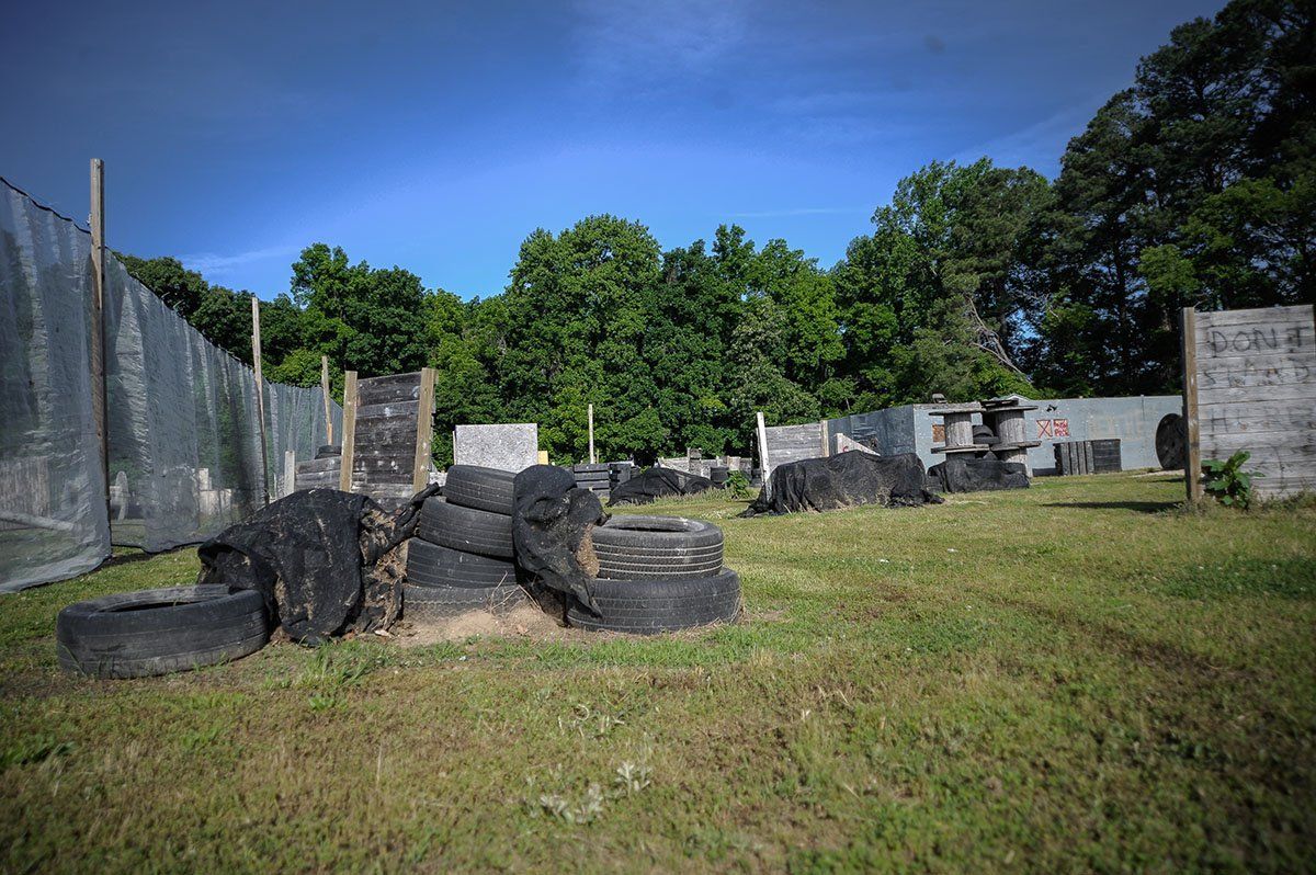 A paintball field with lots of tires and trees in the background.