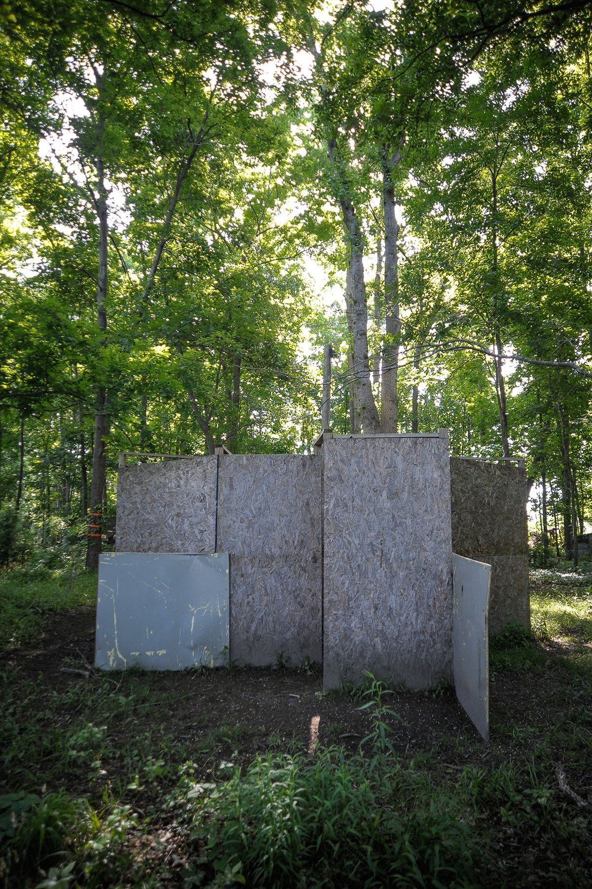 A maze made of wooden boards in the middle of a forest.