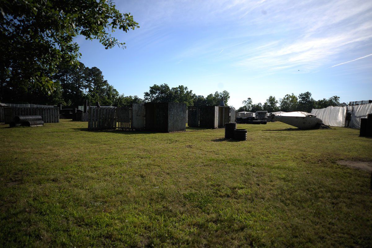 A large grassy field with a lot of buildings in the background