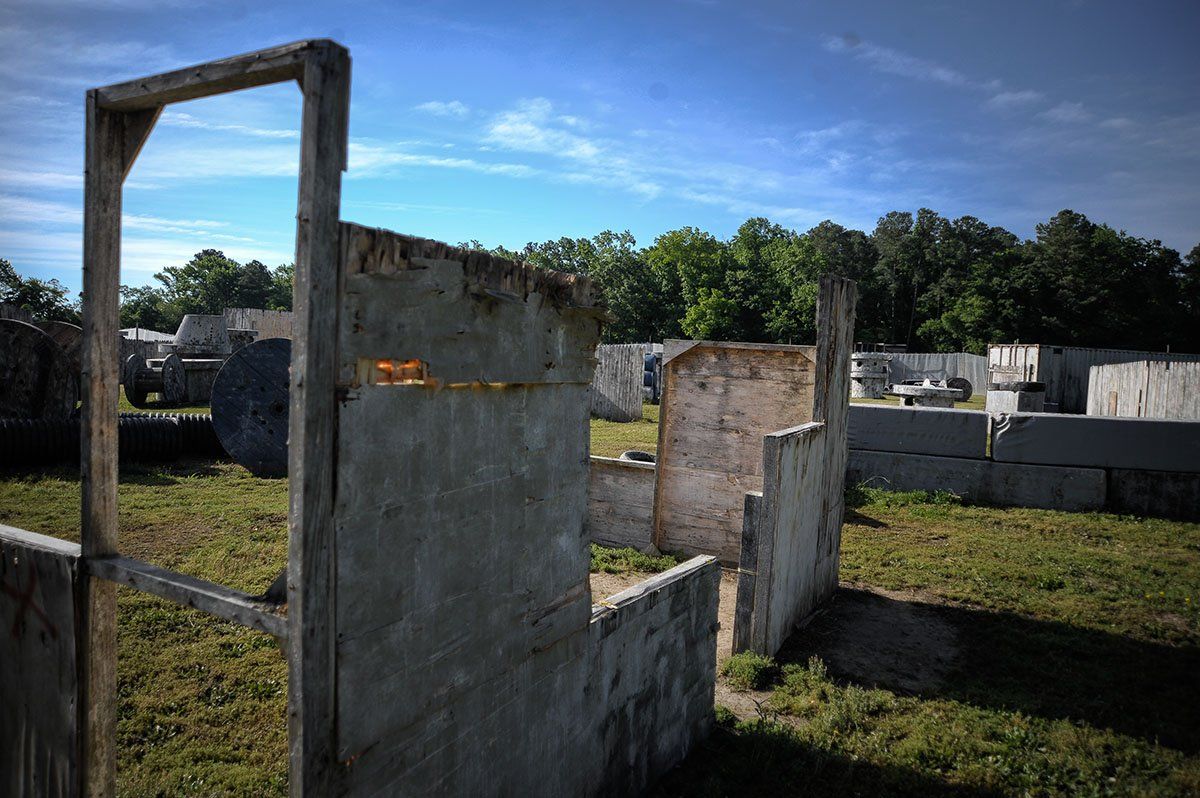 A paintball field with a lot of walls and trees in the background.