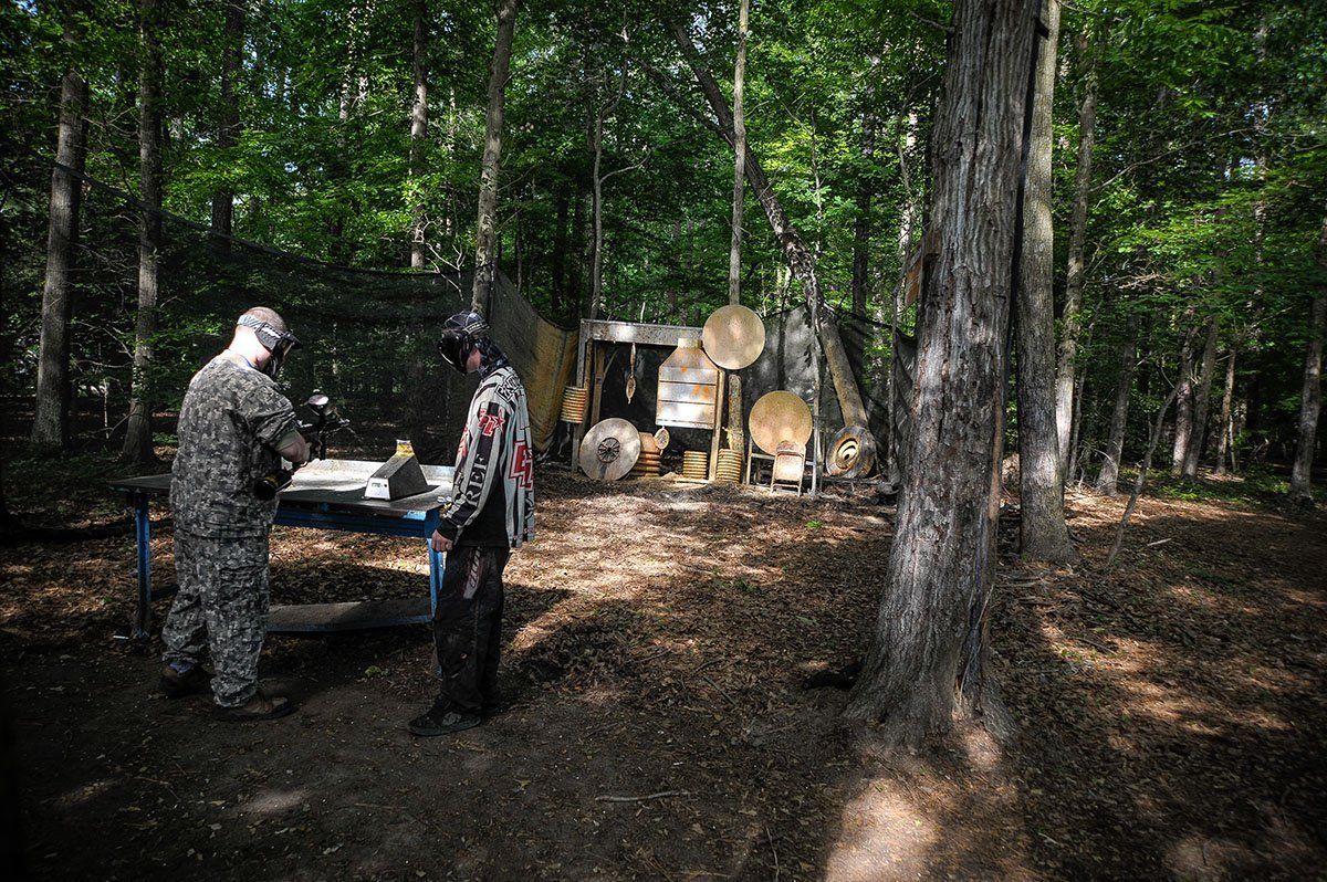 Two soldiers are standing next to each other in the woods.