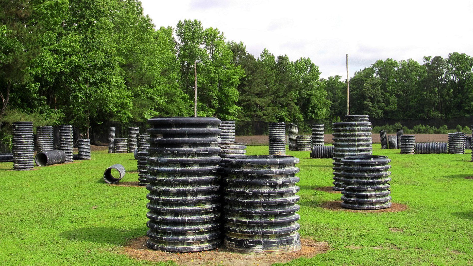 A paintball field with a lot of barrels in it