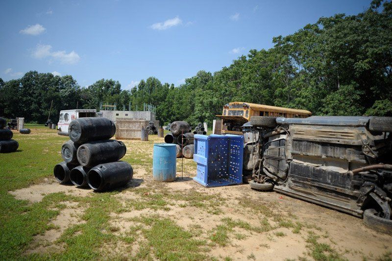 A paintball field with a school bus in the background.