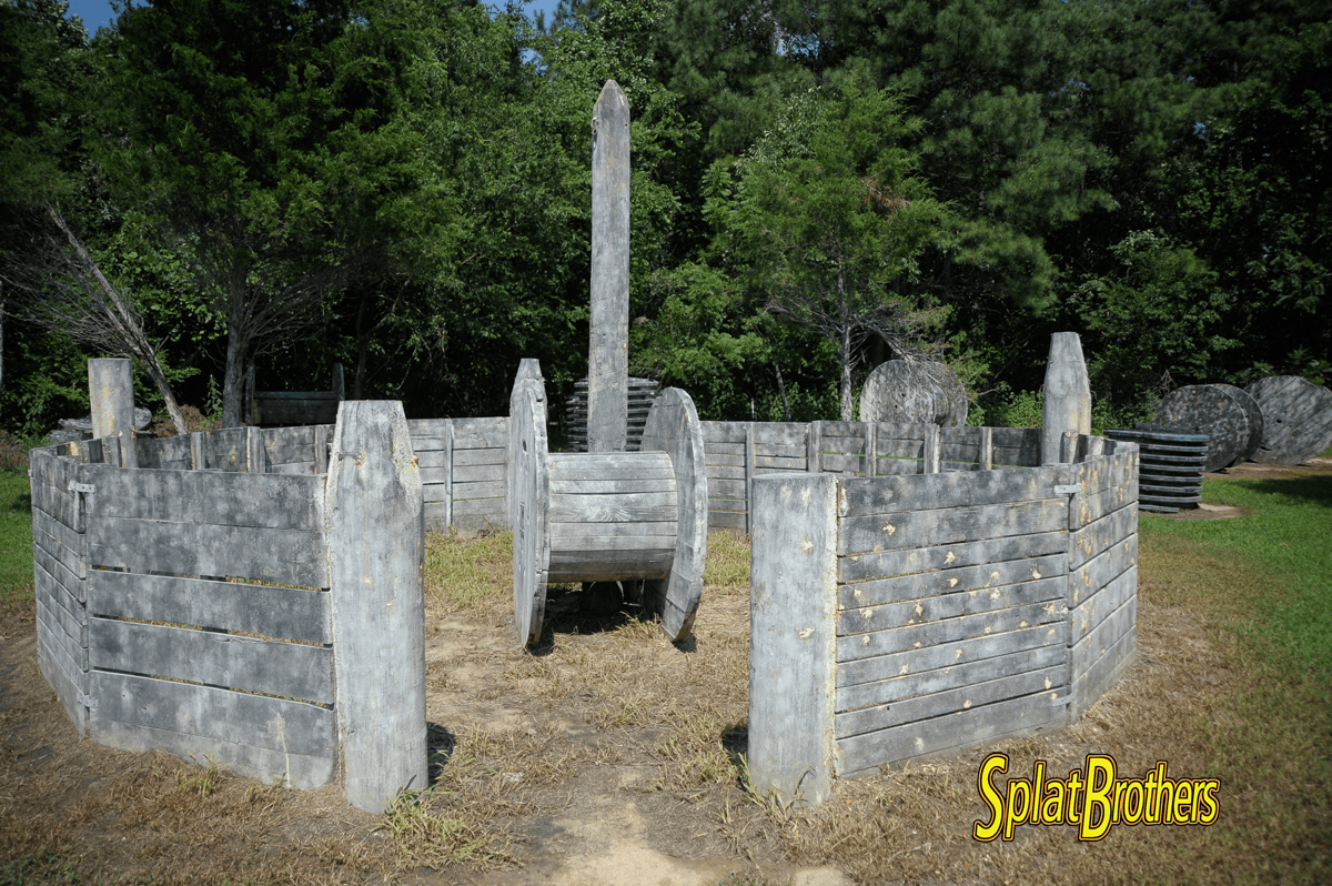 A castle made out of concrete blocks is in the middle of a field.