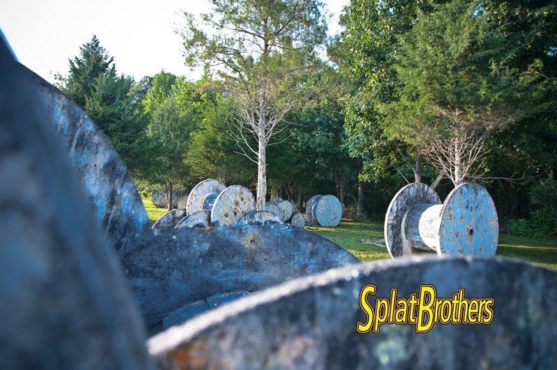A paintball field with a lot of rocks and trees in the background.