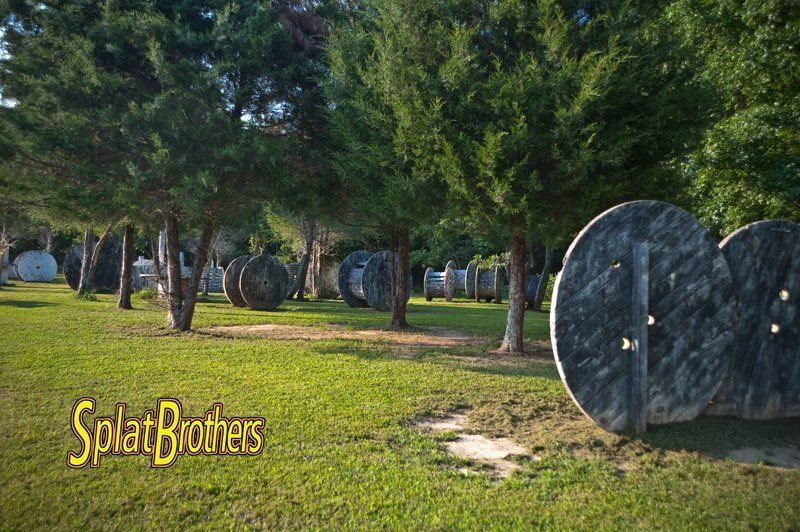 A group of spools are sitting on top of a lush green field.