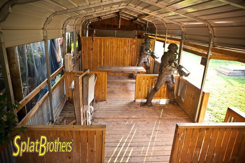 A group of soldiers are standing inside of a wooden building.