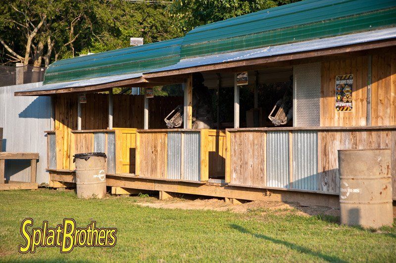 A wooden building with a green roof and a sign that says splatbrothers