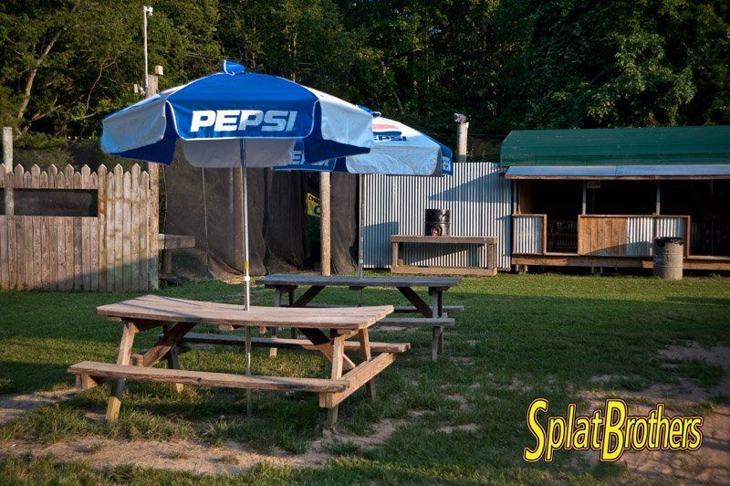 A pepsi umbrella sits over a picnic table