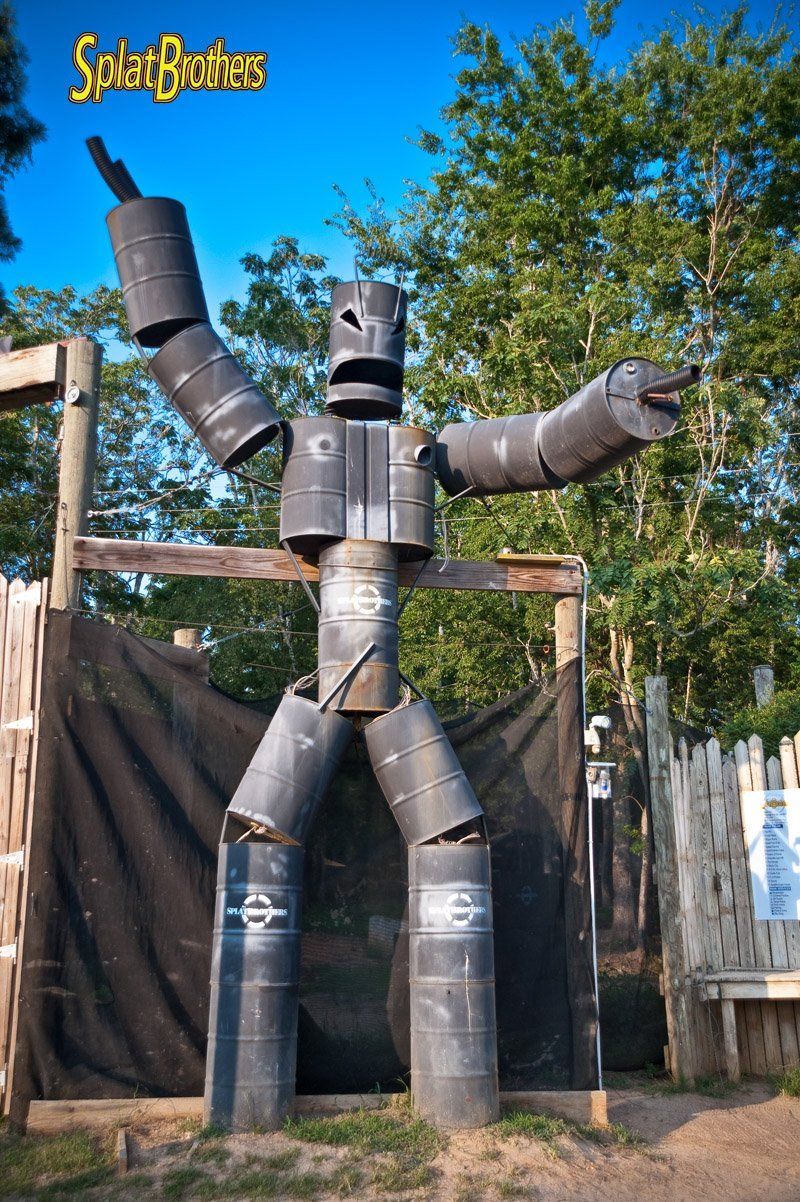 A statue of a robot made out of barrels with the word solar written on the bottom
