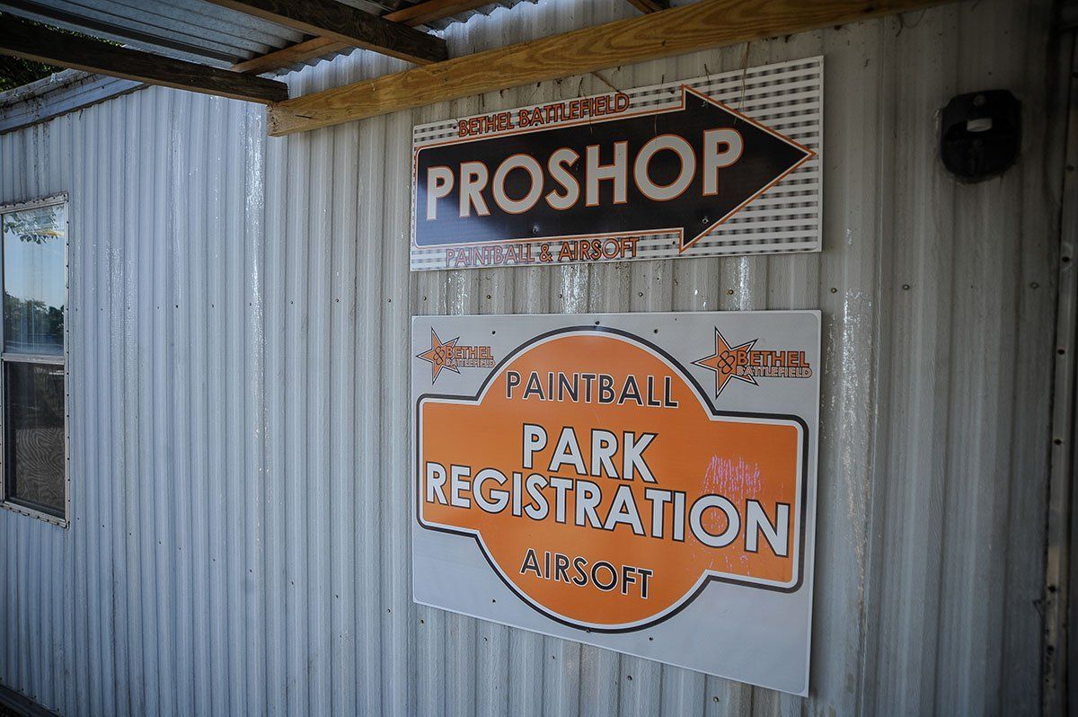 A sign on a building that says proshop paintball park registration