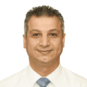 A man in a white shirt and blue tie smiles for the camera