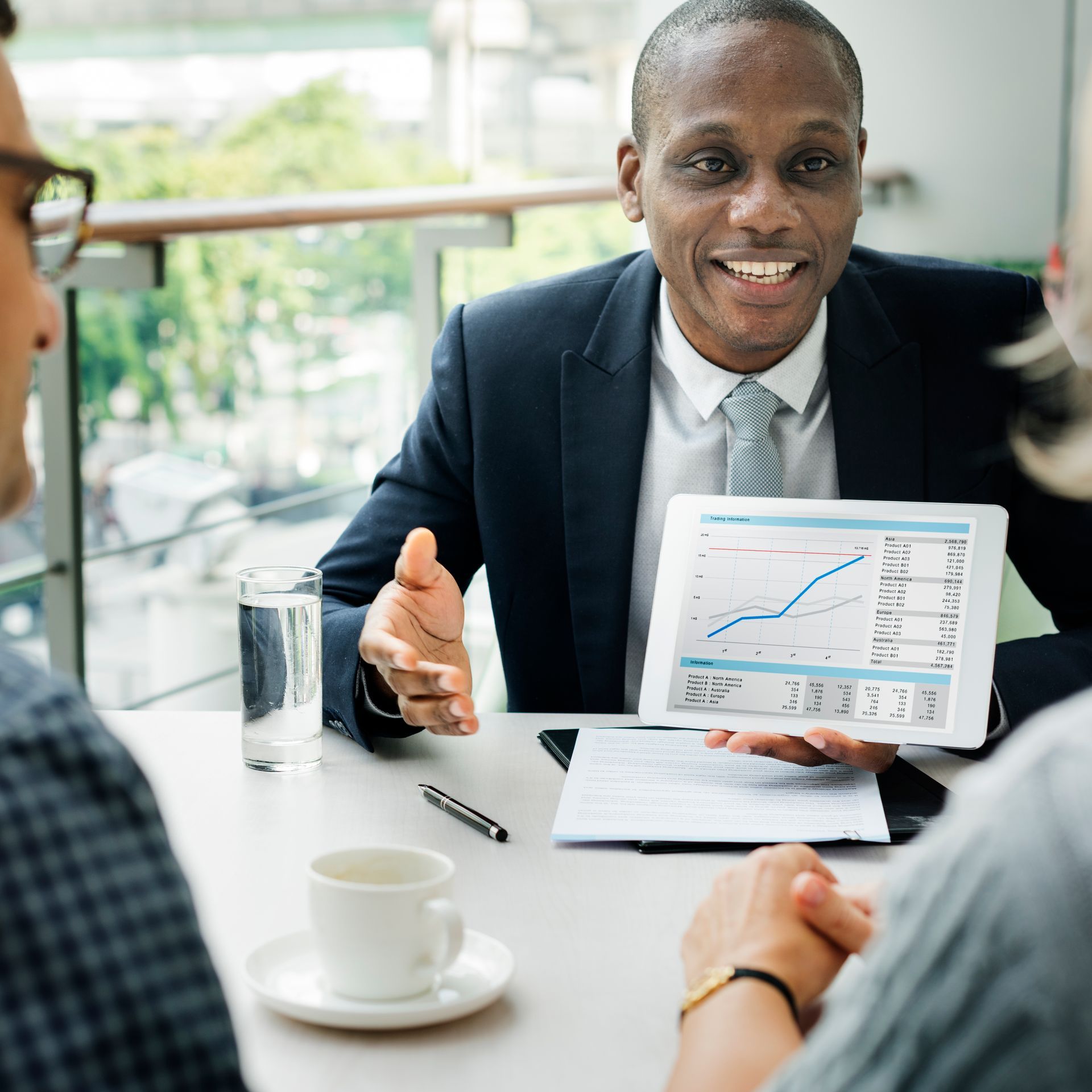 A man is holding a tablet with a graph on it