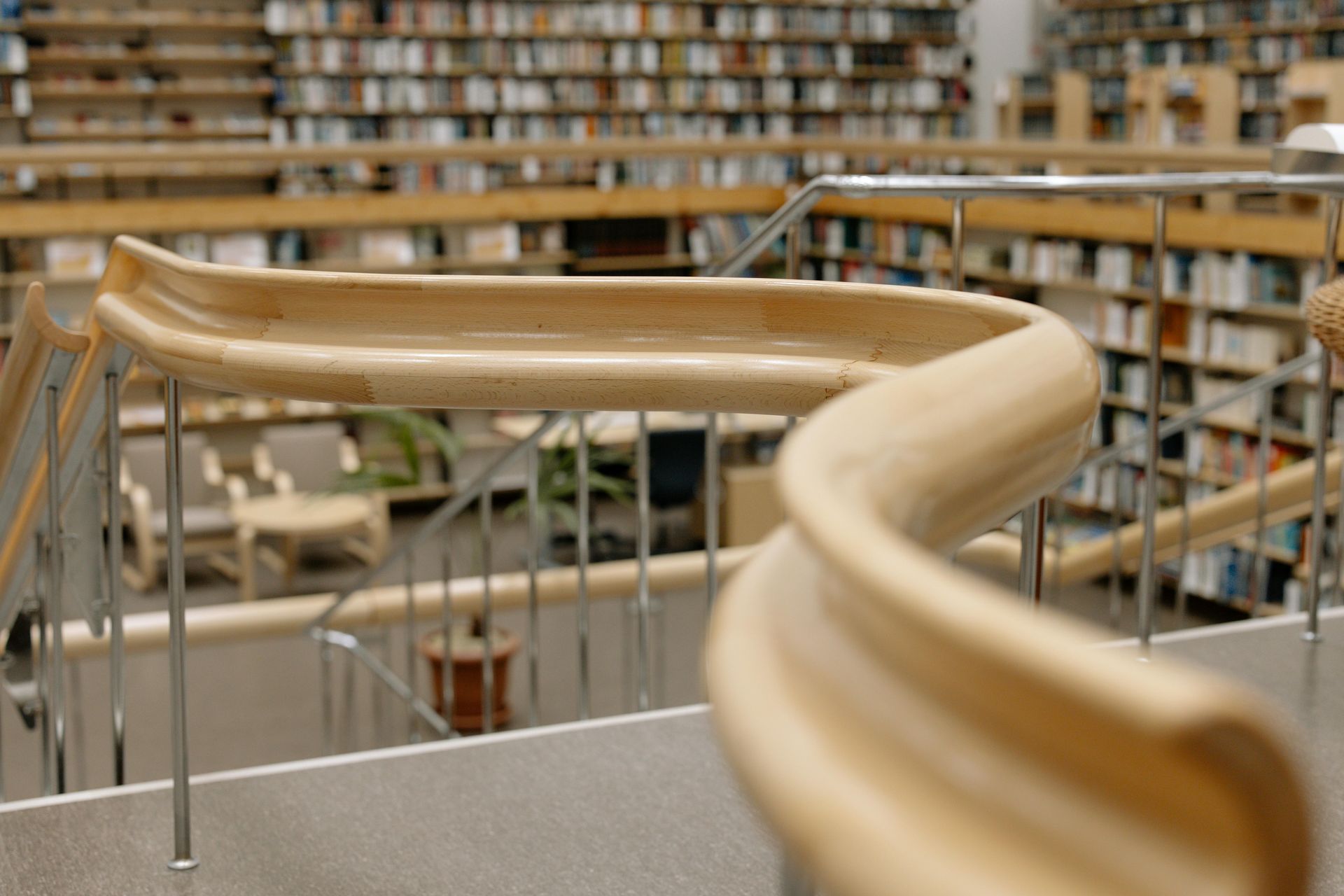 A wooden slide in a library with bookshelves in the background